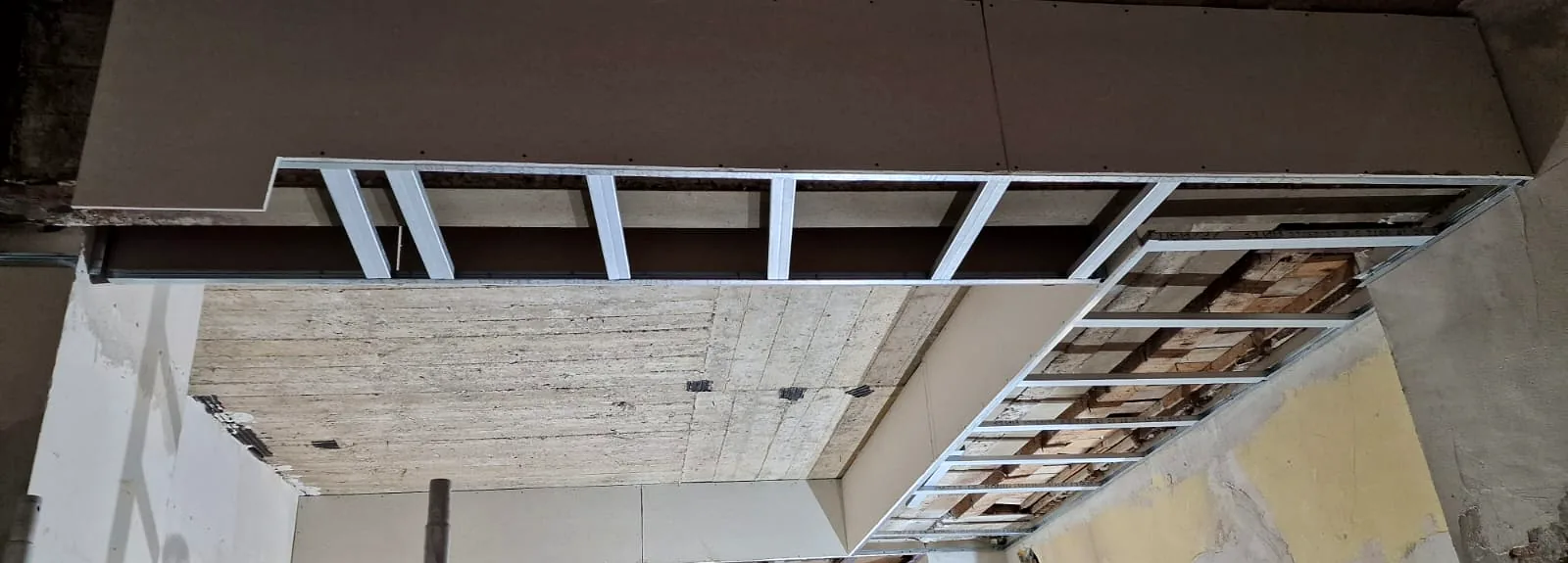 Abgehängte Deckenabschnitte mit Gipskartonbeplankung und Unterkonstruktion unter einer Betondecke